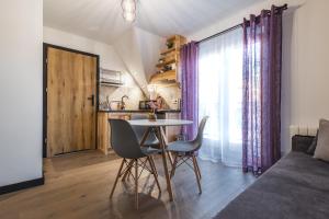 een keuken en een woonkamer met een tafel en stoelen bij Willa na Skarpie in Kościelisko