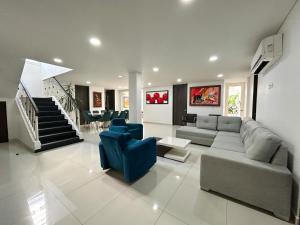 ein Wohnzimmer mit einem Sofa und blauen Stühlen in der Unterkunft Casa Encanto Del Mar in Cartagena de Indias
