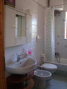 ein Badezimmer mit einem Waschbecken, einem WC und einem Spiegel in der Unterkunft Villa Leonardo in Ischia