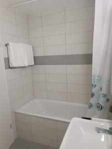uma casa de banho branca com uma banheira e um lavatório em 位于Orbe两室一厅的漂亮公寓 em Orbe