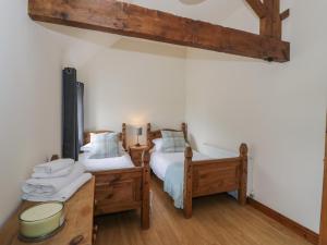 two twin beds in a room with wooden floors at The Hereford Lodge in Stafford