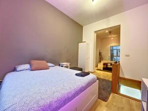um quarto com uma cama e um quarto com uma mesa em Cosy Apartment Brussels - Flagey em Bruxelas