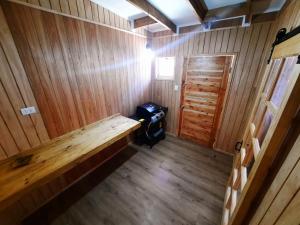 una habitación vacía con un banco en una cabaña de madera en Casa Bellavista Full Equipada, en Tomé