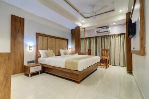 a bedroom with a bed and a television in it at Hotel Flysky Rooms & Banquets in Navi Mumbai +34 photos