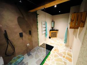 La salle de bains est pourvue d'une douche et de carrelage. dans l'établissement L'appar-T loft avec Spa privatif et jardin, à Gières
