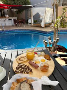 una bandeja de comida en una mesa junto a una piscina en Villa Jade, en Dakar