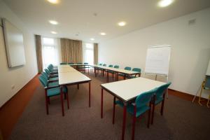 une salle de classe avec des tables et des chaises et un tableau blanc dans l'établissement Garni Hotel Danja Herold e. U., à Maria Lankowitz