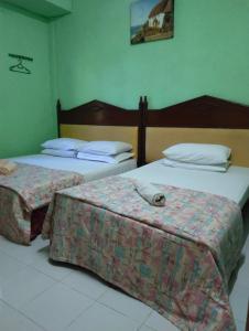 twee bedden in een hotelkamer met twee bij Adeeva Homestay Langkawi in Pantai Cenang