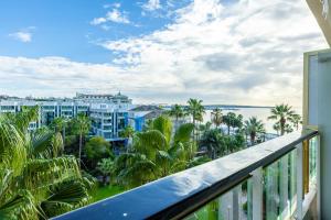 d'un balcon avec vue sur l'océan et les palmiers. dans l'établissement Agence des Résidences - Appartements privés du 45 CROISETTE- Prestige, à Cannes