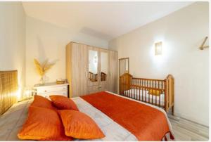 1 dormitorio con cama con almohadas de color naranja y cuna en Casa Iribarne, en Rodalquilar