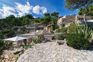 a house with a stone walkway with a patio at La Casa del Fico in Leuca