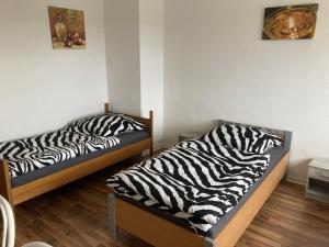 2 camas en una habitación con sábanas de cebra en Rentarooms, en Wathlingen