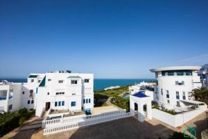 a view of two white buildings and the ocean at Appartement avec vue sur mer in Gammarth
