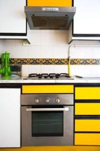cocina con fogones y armarios amarillos y blancos en Appartement avec vue sur mer, en Gammarth