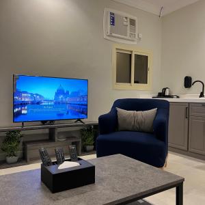 a living room with a blue couch and a flat screen tv at شقق سنتارا الفندقية in Taif
