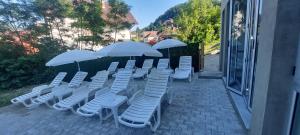 Jošanička Banja的住宿－Apartmani Matin Breg，庭院里摆放着一组椅子和遮阳伞