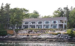 a large house on the shore of a body of water at Linekin Bay Resort in Boothbay Harbor