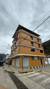 ein gelbes Gebäude an der Straßenseite in der Unterkunft Hostal Tinkoj in Chavín de Huantar