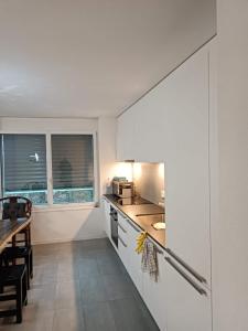 uma cozinha com paredes brancas e uma mesa e um balcão em 位于Orbe两室一厅的漂亮公寓 em Orbe