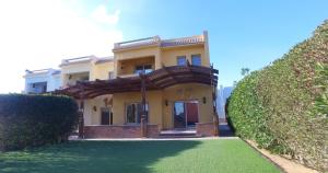 Casa amarilla con balcón y patio verde en Utopia Villas - Ain Soukhna en El-Hafâyir