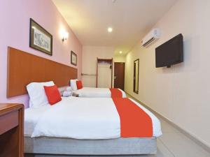 a bedroom with a bed and a tv on the wall at MRC Hotel Melaka Raya in Melaka