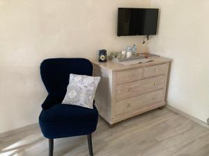 コティニャックにあるMaset des Amandiersの椅子とドレッサー(テレビ付)が備わる客室です。
