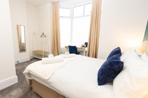 a bedroom with a large bed with blue pillows at Suite 1 - Lovely Ensuite in Oldham Sociable House in Oldham