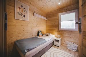 チェルヴェナー・ヴォダにあるApartmán Andreaの小さなベッドルーム(木製の壁のベッド付)