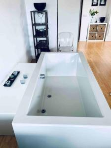 a white bath tub sitting in a room at Designer Room with Private Bathroom in London