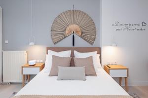 卡拉马塔Singer Suite Kalamata , Close to Center & Easy Street Parking的卧室配有白色床,墙上设有大风扇