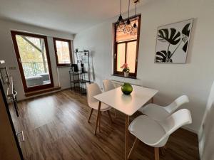 a dining room with a white table and white chairs at Ferienwohnung am Markt in Kirchberg