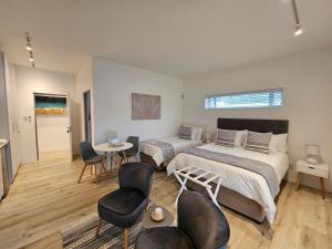 Jeffreys Bay的住宿－Point Villa，一间卧室配有两张床和一张桌子及椅子