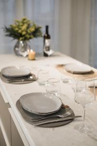 a table with plates and wine glasses on a counter at A Comfortable Stay with Balcony and Easy Parking near Kalamata Center in Kalamata