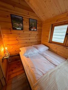 um quarto com uma cama num chalé de madeira em Dwór Piotra i Pawła- pokoje i domki em Miedzygorze