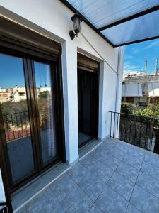 Un balcón de una casa con grandes ventanas de cristal en Pyrgi Village apartment, en Pyrgi