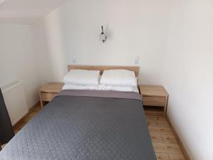 Cama en habitación con paredes blancas en Apartamenty Domki Pokoje WeMa Wicie, en Wicie