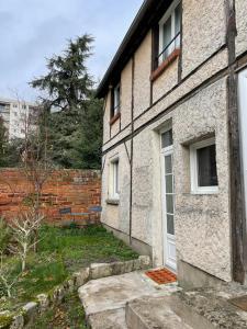 a brick house with a white door and a yard at Sleepin Orléans - Parking - Netflix in Orléans