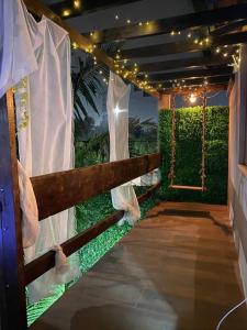 une véranda avec une clôture, une balançoire et des lumières dans l'établissement Alugo espaço com piscina + Jacuzzi!, à Mogi das Cruzes