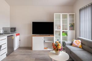 ein Wohnzimmer mit einem Sofa und einem TV in der Unterkunft West Swan B&B in Perth