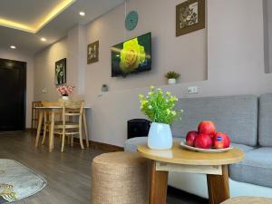 a living room with a couch and a table with fruit on it at NALINI Hotel & Apartment in Da Nang