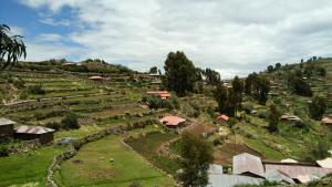 una vista aérea de un pequeño pueblo en una colina en BLUE SKY Lodge Taquile en Huillanopampa