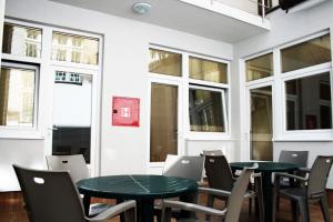 a room with two tables and chairs and windows at Hostel Mak in Sarajevo