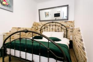a bedroom with a wrought iron bed with a mirror at Gong Apartments in Sibiu