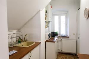 a kitchen with white cabinets and a sink and a window at Gong Apartments in Sibiu
