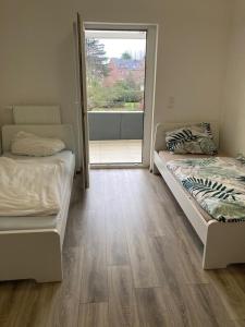 2 letti in una camera con una grande finestra di NT Dreamhouse a Düren - Eifel