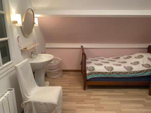 a small bathroom with a bed and a sink at Le Carbet Hardelot-Plage in Neufchâtel-Hardelot