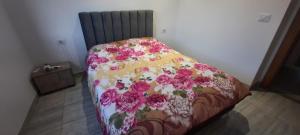 a bed with a floral blanket on it in a room at Vip appartement tunis in La Goulette