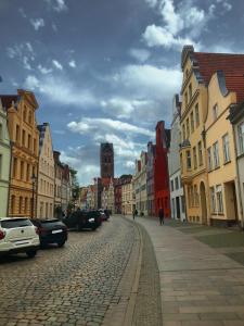 uma rua de calçada numa cidade com edifícios em Hansestübchen em Wismar