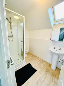 ein Bad mit einer Dusche, einem Waschbecken und einem WC in der Unterkunft 3 Bedroom Affordable Family Detached House - Business Contractors, Midlands Location - Private garden,Free car park,TV- Netflix and Free WiFi in Coventry