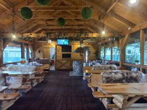 un restaurante con suelo de madera, mesas y sillas en Grabska Osada SUN HOUSE - domki całoroczne ogrzewane en Grabce